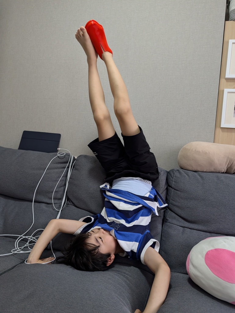 Kanata lying on a sofa with his feet up, wearing the red test upper